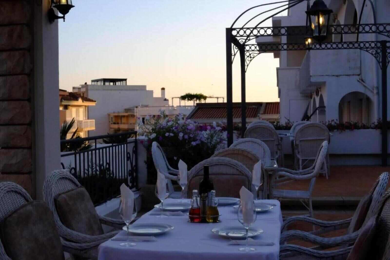 Restaurant table on the terrace at sunset at H Kleopatra
